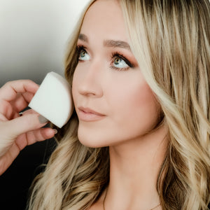 A lady using StansOut makeup sponge