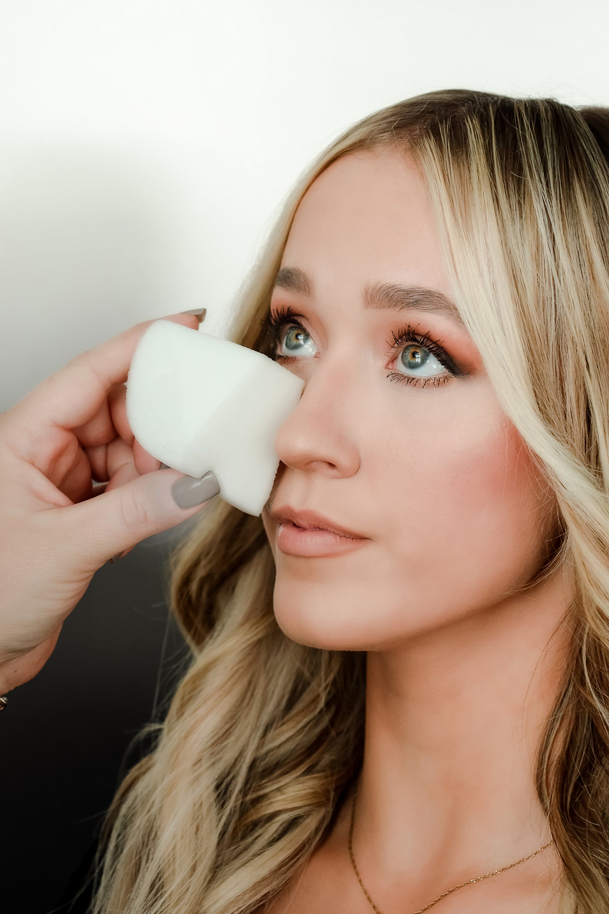 A lady using makeup sponge