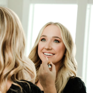 A lady applying Lip Gloss