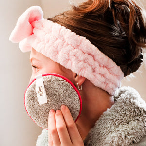 A lady using Makeup removing rounds and skincare headband